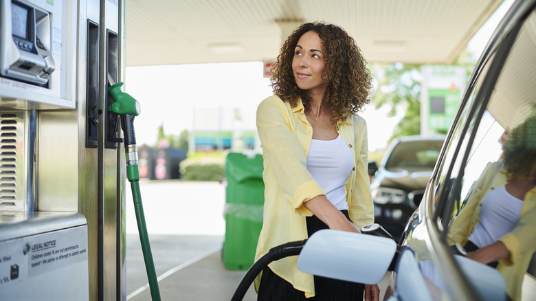 woman filling tank at gas station