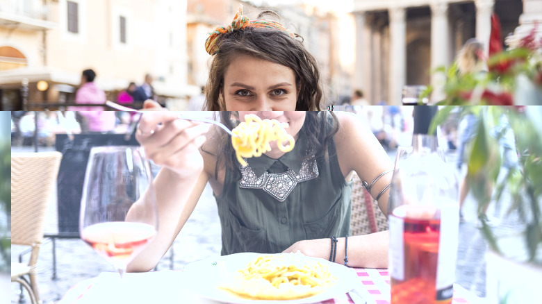Woman eating pasta in Rome
