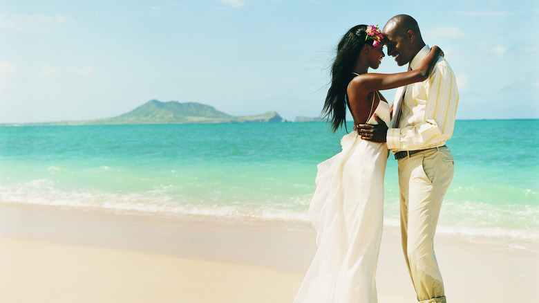 Couple in wedding clothes on beach