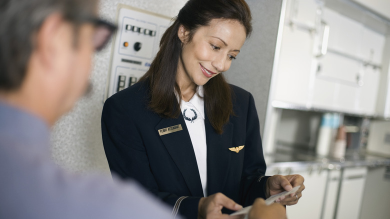 Flight attendant checking a boarding pass