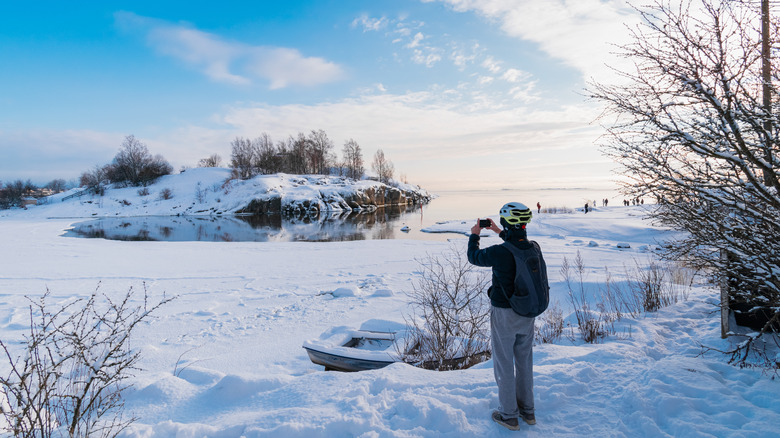 Visitor photographing Uunisaari in winter