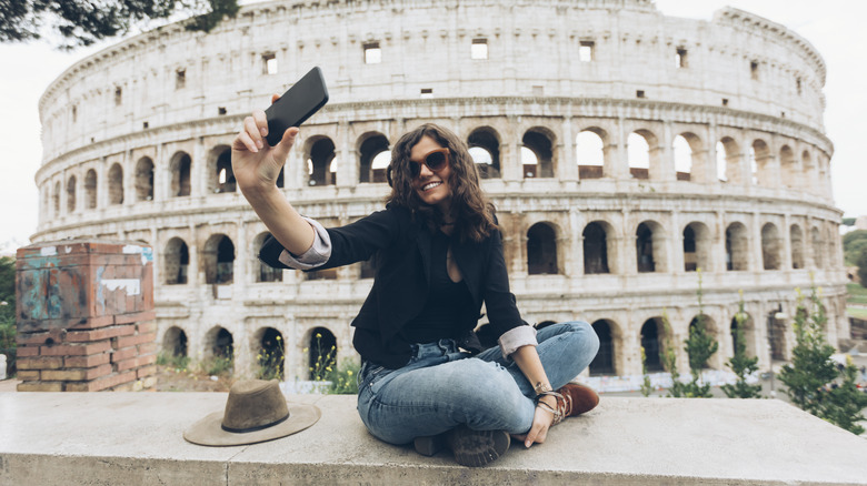 woman taking picture with Colosseum